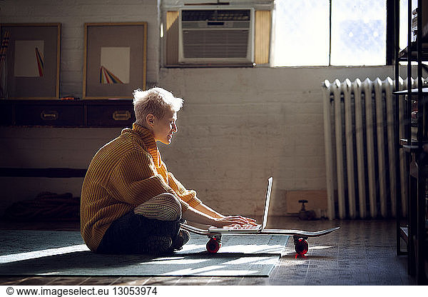 Woman using laptop computer while sitting at home