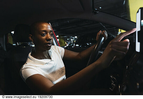 Woman using mobile phone in car