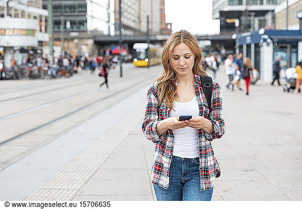 Woman using smartphone in the city  Berlin  Germany