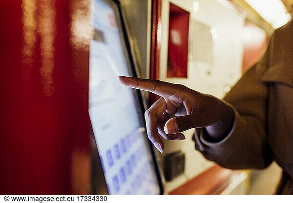Woman using ticket machine at subway station