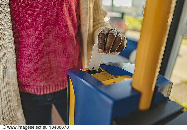 Woman using ticket machine in tram