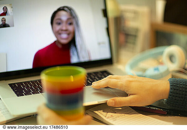 Woman video chatting with colleagues at laptop screen