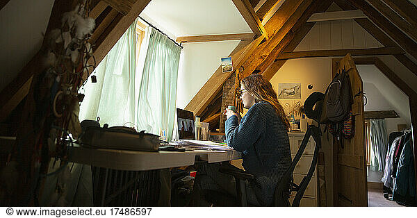 Woman video conferencing at laptop in home office