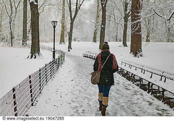 Woman walking in central park during a snow storm