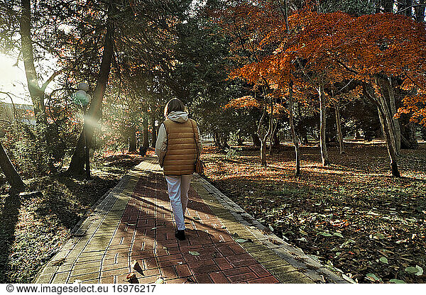 Woman walking in park at autumn time