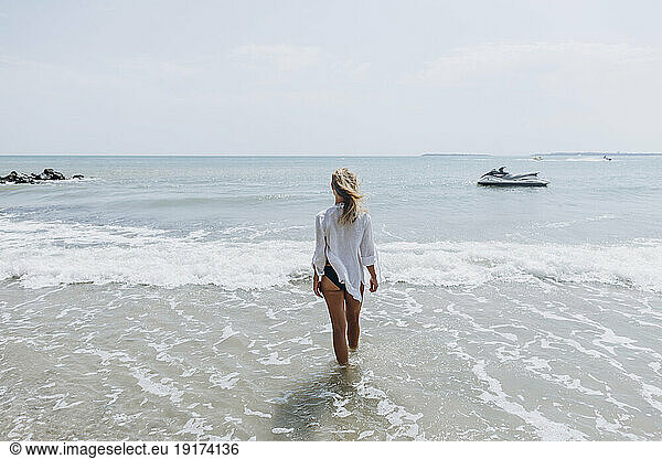Woman walking in water at beach