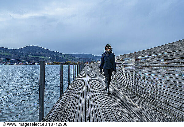 woman walking on boardwalk over lake close to Zurich