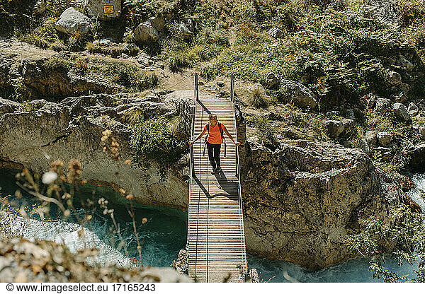 Woman walking on bridge while exploring Cares Trail in Picos De Europe National Park  Asturias  Spain
