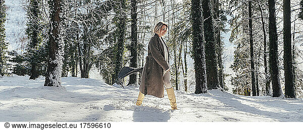 Woman walking on deep snow in forest