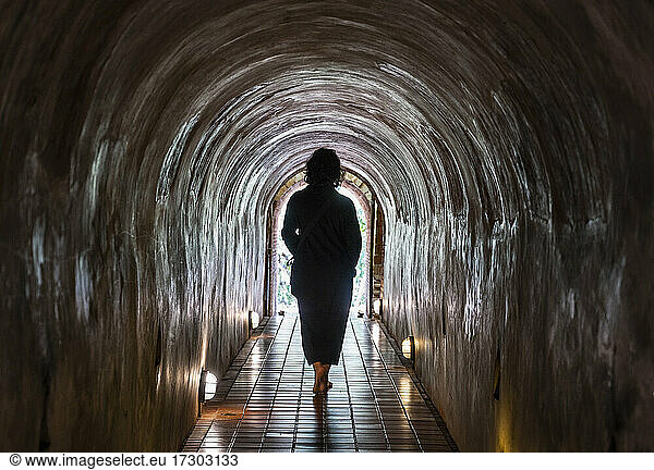 Woman walking through the tunnel's of the Temple Wat Umong
