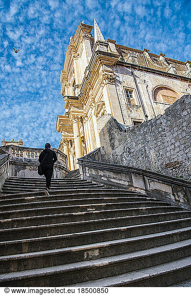 woman walking up the stairs to the Cathedral in Dubrovnik