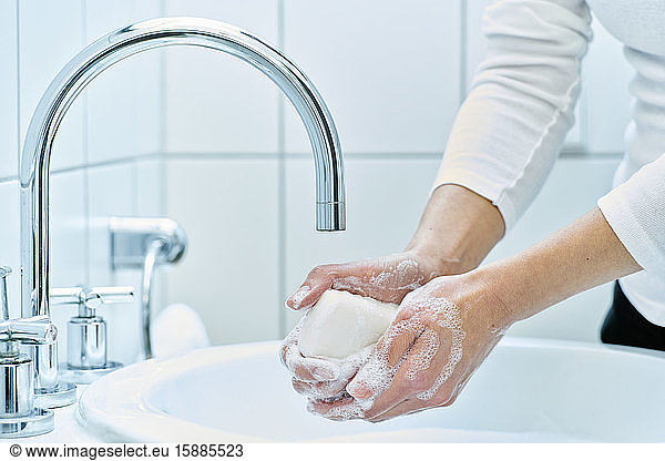 Woman washing her hand with soap