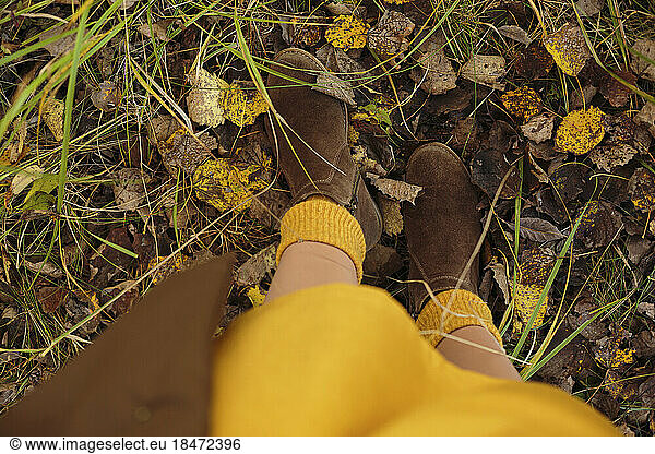 Woman wearing boots standing on fallen leaves