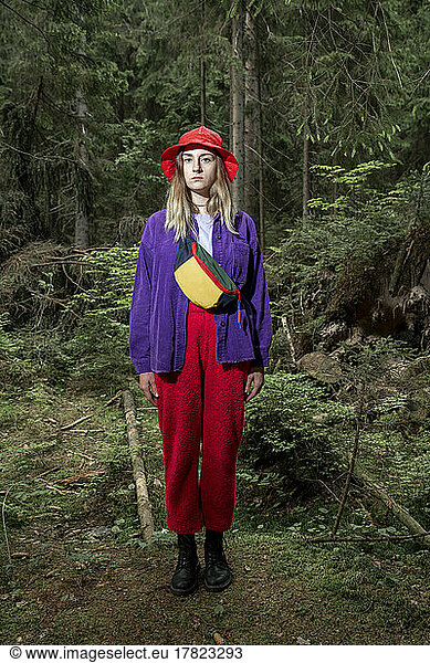 Woman wearing bucket hat standing in forest