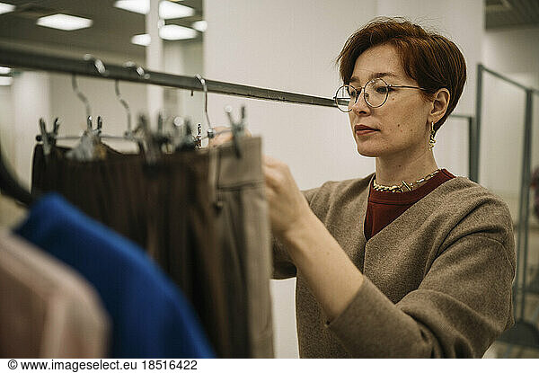 Woman wearing eyeglasses working in clothes store