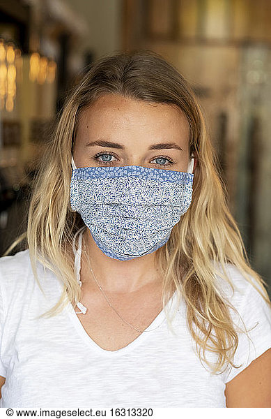 Woman wearing face mask shopping in waste-free local store  sustainability.