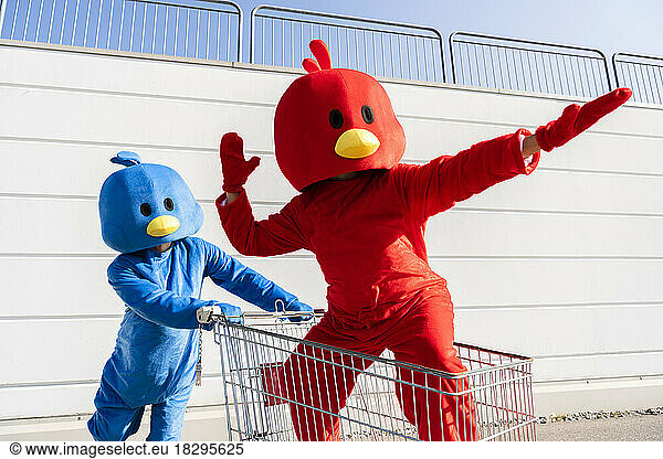 Woman wearing red duck costume standing in shopping cart