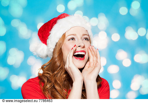 Woman wearing santa hat, shouting