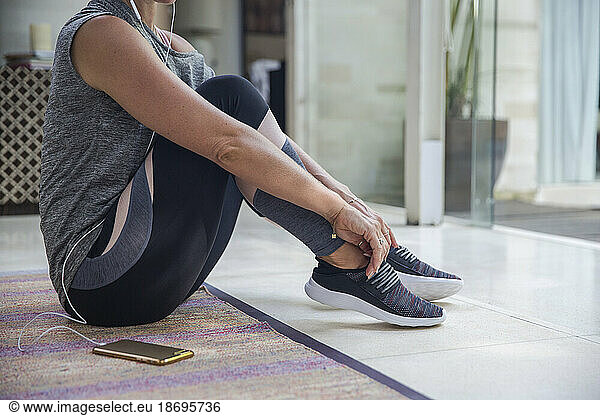Woman wearing shoes sitting on floor at home