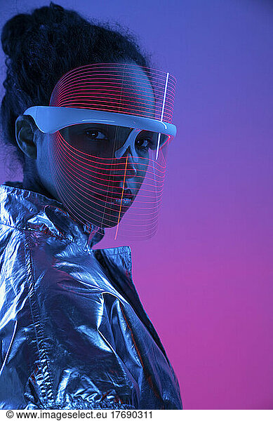 Woman wearing smart glasses against multi-colored background