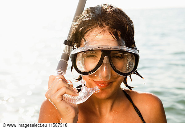 Woman wearing snorkel in water