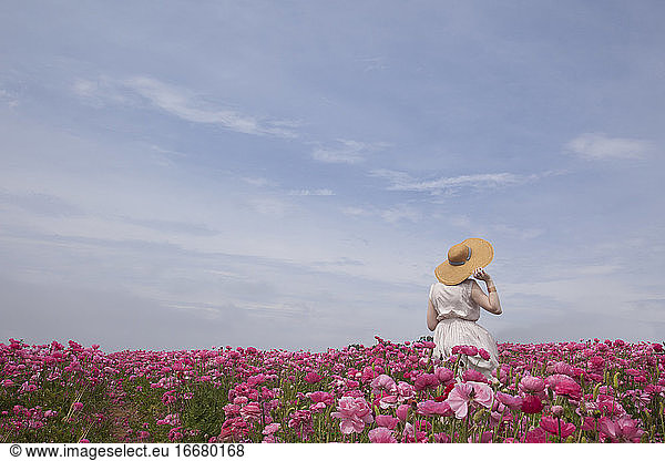 Woman wearing straw hat in pink flowers