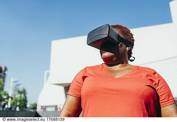 Woman wearing virtual reality simulator on sunny day