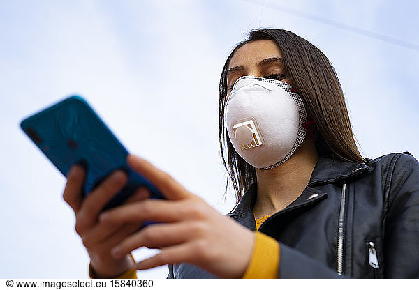 Woman with a doctor mask using the phone. Virus protection.