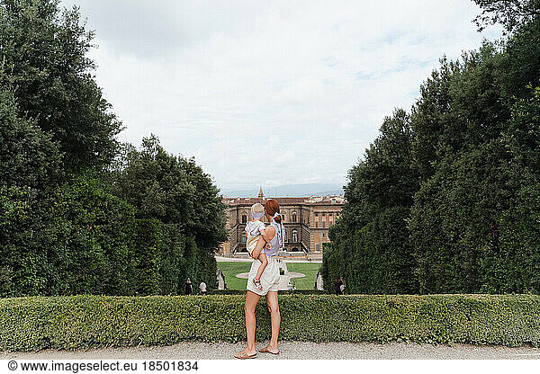 Woman with a toddler in her arms in the Boboli Gardens viewpoint
