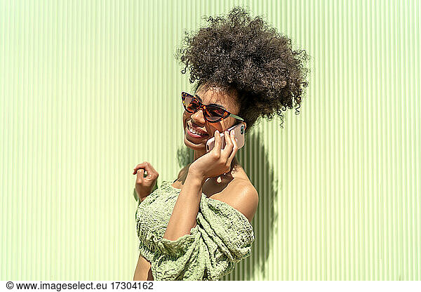woman with afro hair talking from her smartphone