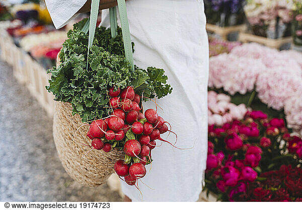 Woman with bag of various vegetables in market