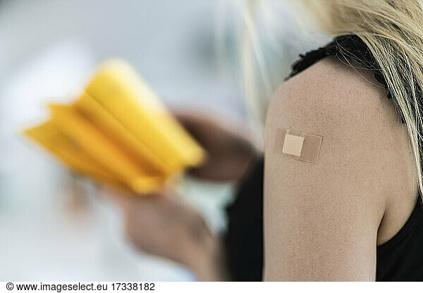 Woman with bandage on arm at vaccination center
