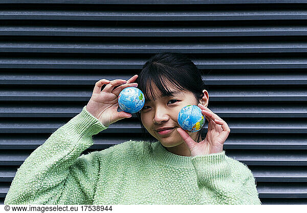 Woman with bangs holding small globes
