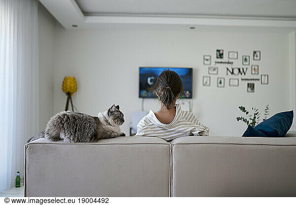 Woman with cat sitting on sofa at home
