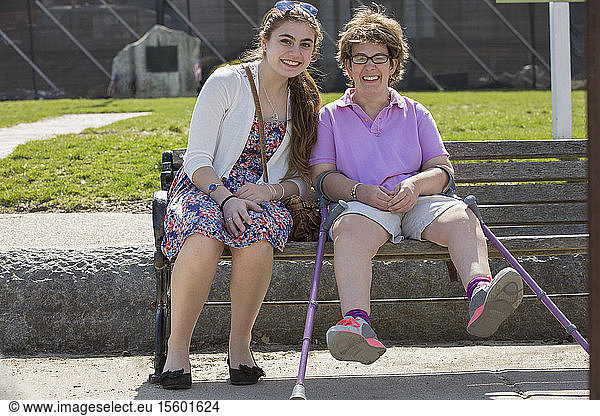 Woman with Cerebral Palsy sitting with her sister in a park