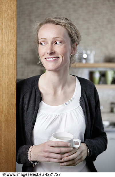 Woman with coffeecup at home