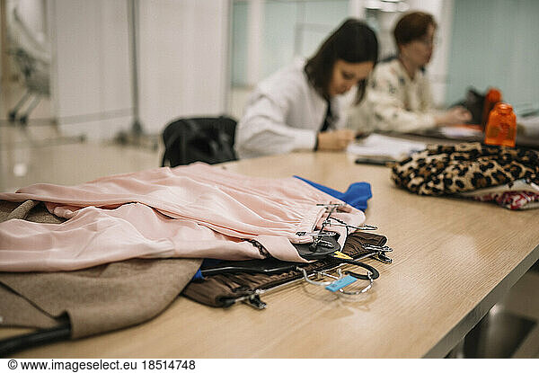 Woman with colleague examining clothes at clothing store