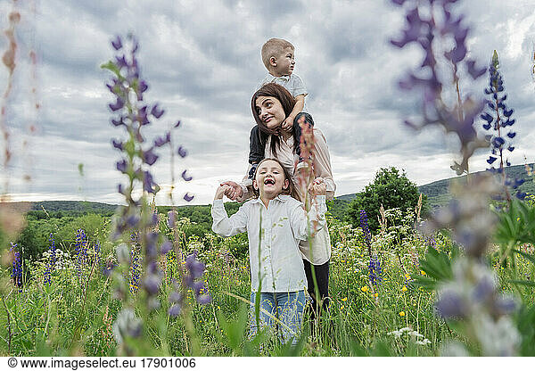 Woman with daughter and son in wildflowers meadow