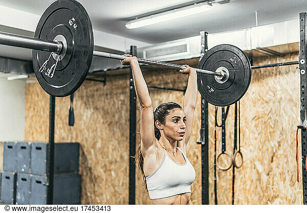 woman with dumbbells in the gym doing crossfit