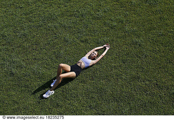Woman with eyes closed lying on grass