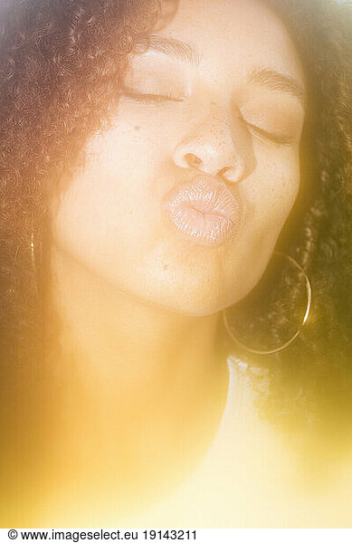 Woman with eyes closed puckering lips