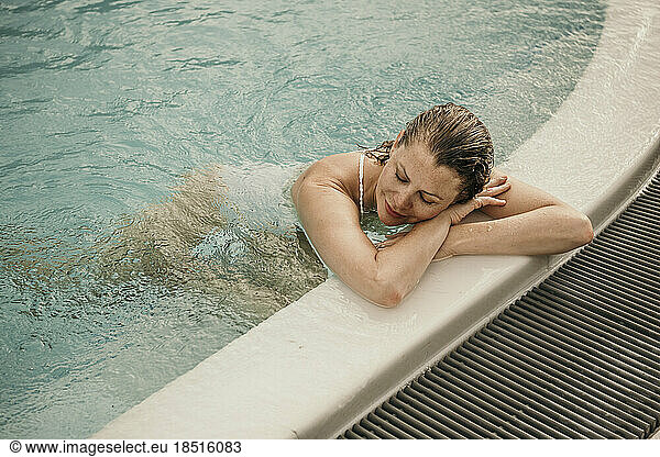 Woman with eyes closed resting in swimming pool