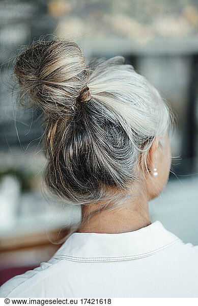 Woman with gray hair bun in cafe