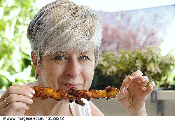 Woman with grilled chicken on a balcony