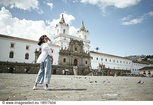 Woman with hand in hair standing in front of Plaza de San Francisco