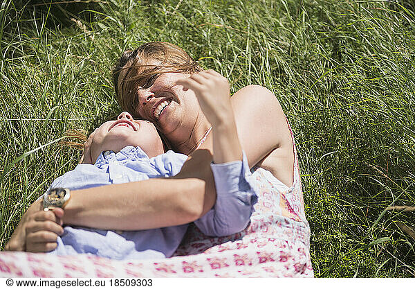 Woman with her son lying on grass and enjoying picnic  Bavaria  Germany