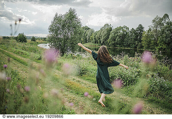 Woman with long hair dancing in field