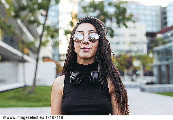 Woman with long hair in sunglasses and headphones on her neck