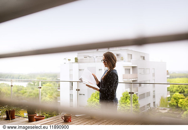 Woman with notebook standiing on balcony