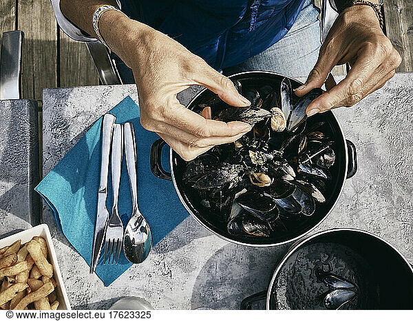 Woman with oysters at table on sunny day